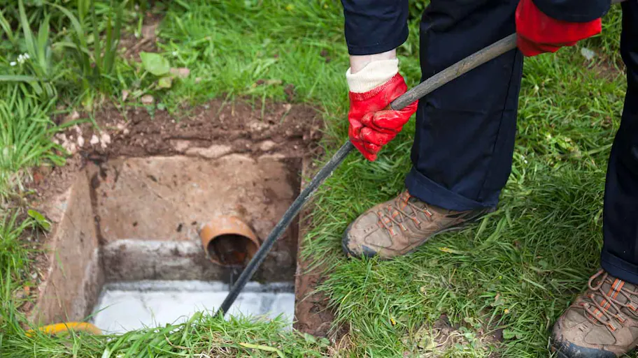 man-unblocking French Drain Cleaning