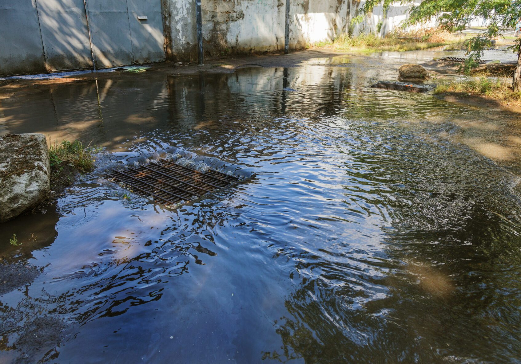Flow of water during heavy rain and clogging of street sewage. The flow of water during a strong hurricane in storm sewers. Sewage storm system along the road to drain rain into the drainage system